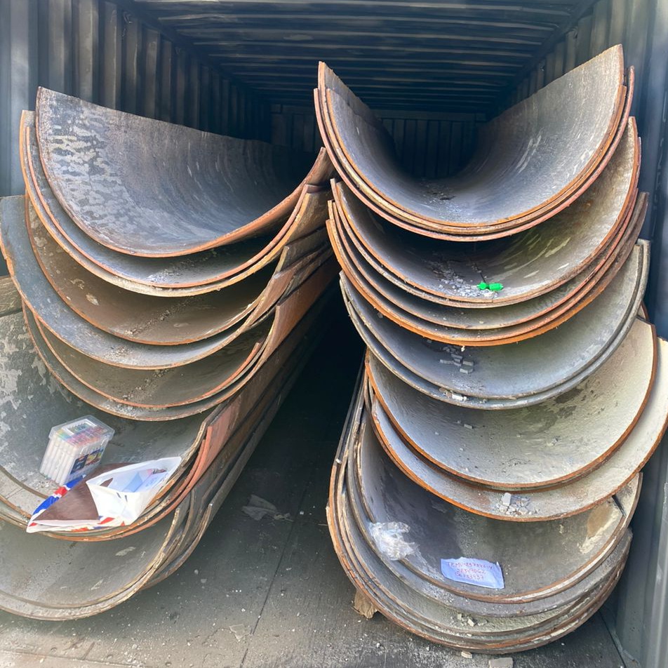 Piles of various scrap metal pipes in a junkyard